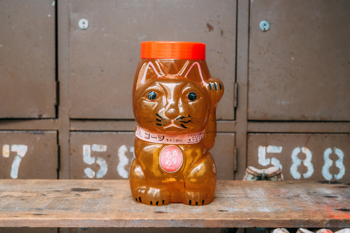招き猫の形をした飴色の半透明プラスチック容器