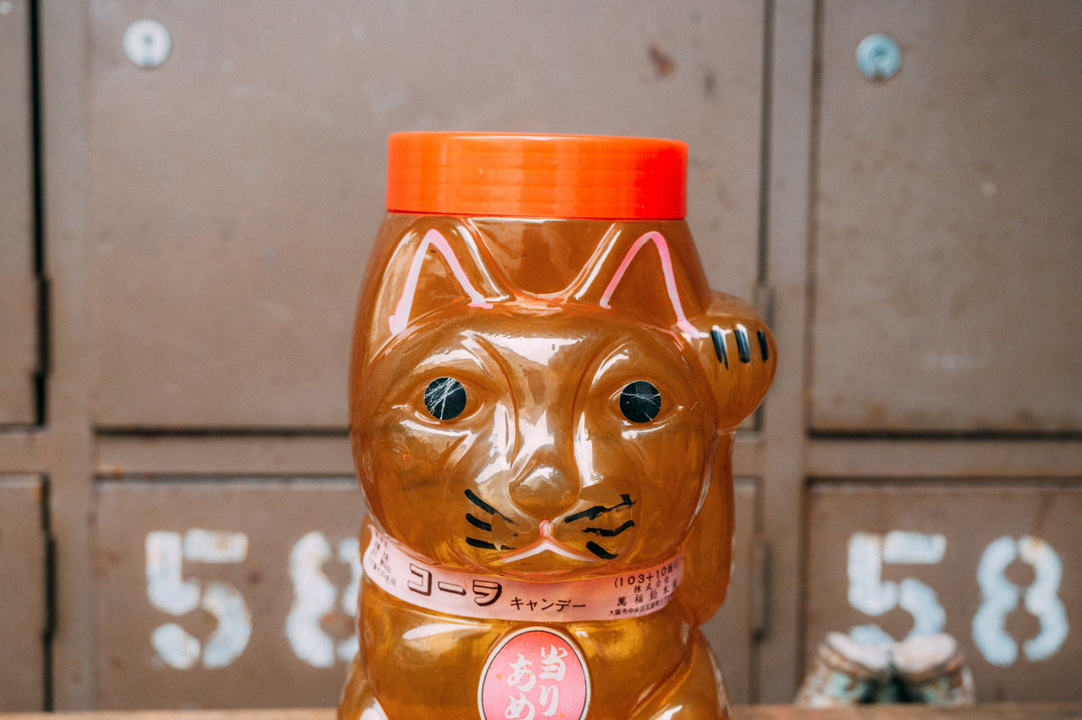 招き猫の形をした飴色の半透明プラスチック容器
