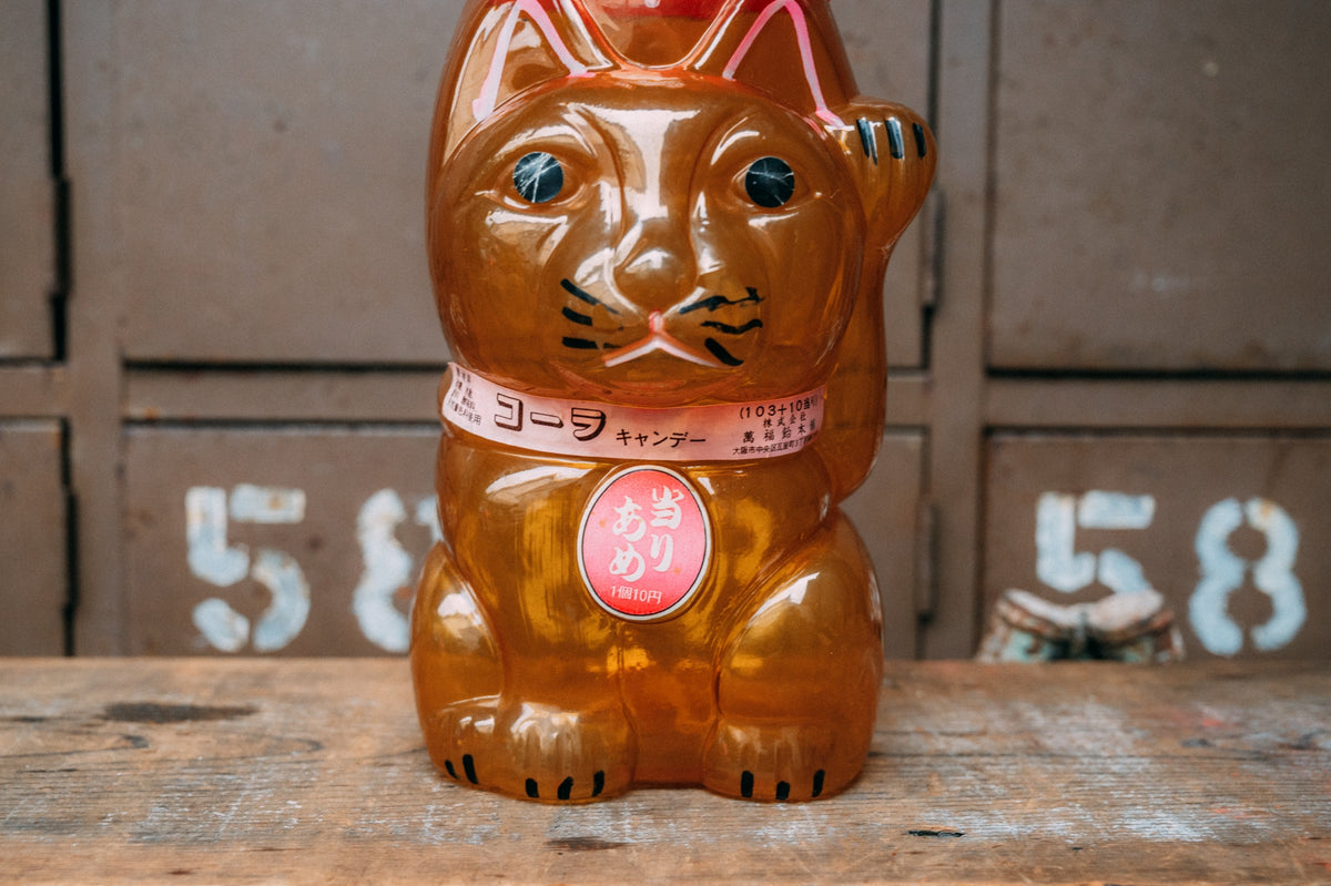 招き猫の形をした飴色の半透明プラスチック容器