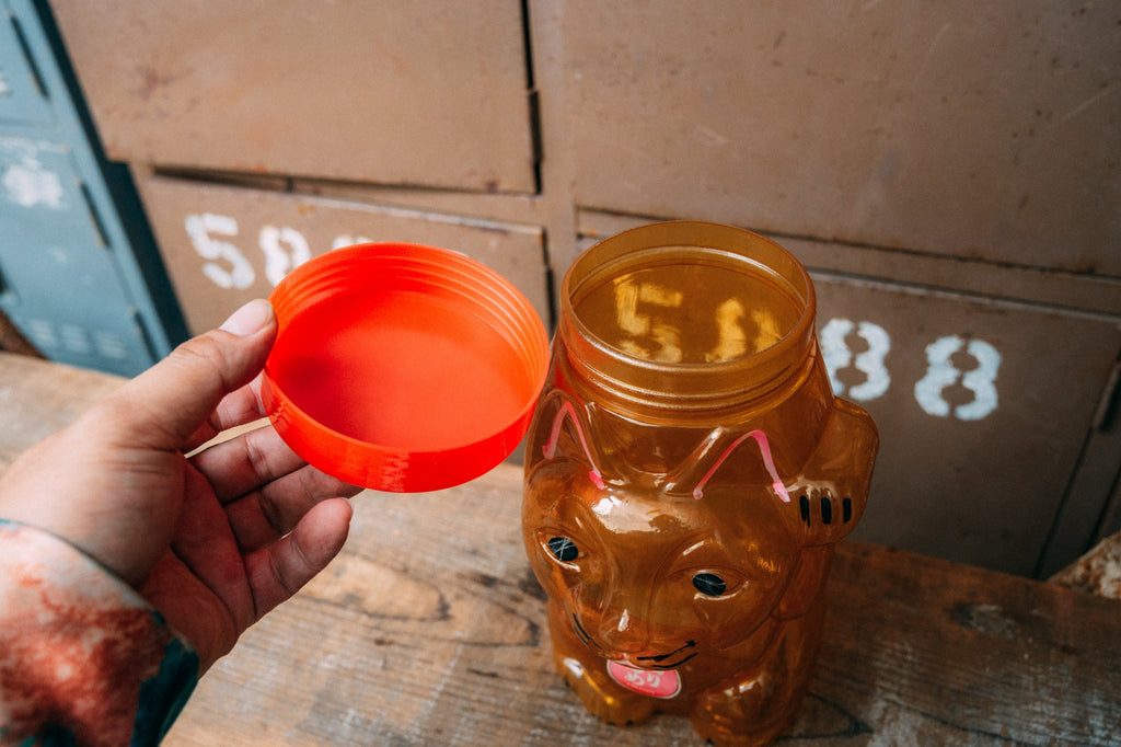招き猫の形をした飴色の半透明プラスチック容器
