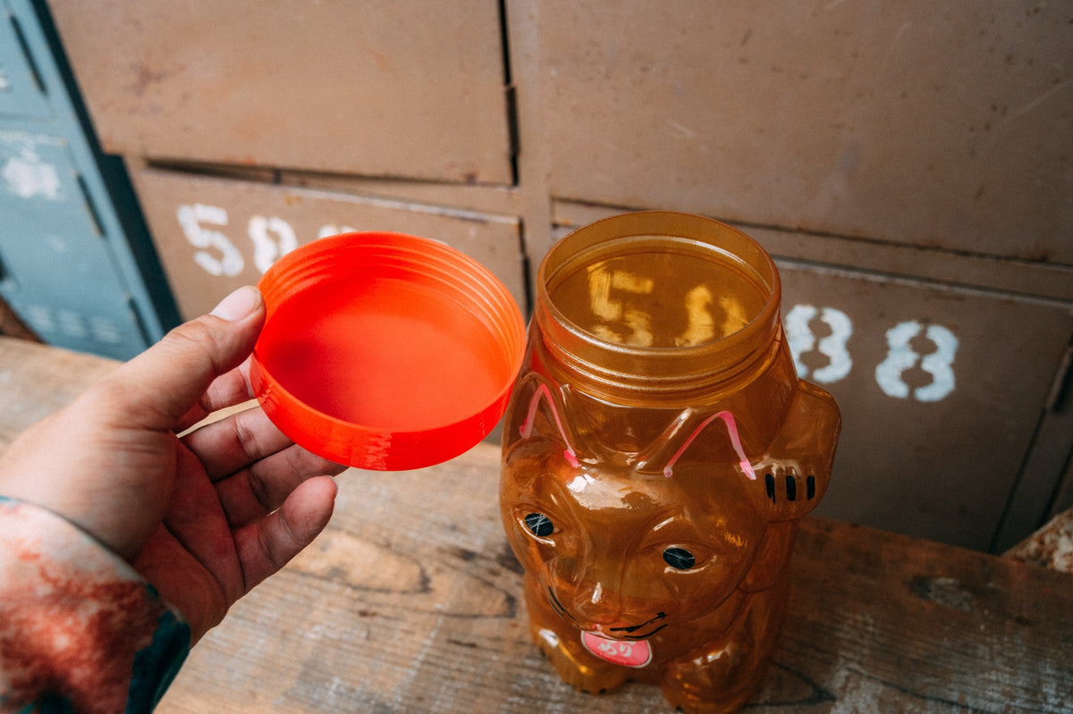 招き猫の形をした飴色の半透明プラスチック容器